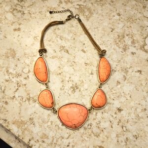Coral colored stone necklace with rope and metal clasp.